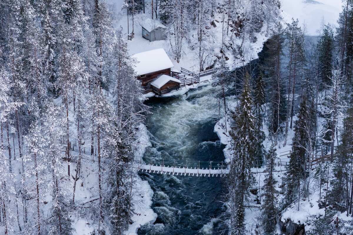 Punainen mökki lumisessa maisemassa hiihtolatujen lähellä
